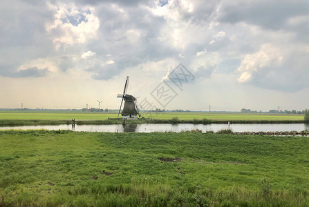 荷兰的风力车反射绿色运河背景图片