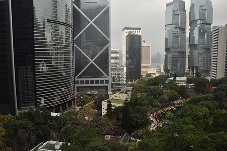 香港未来城市建筑的景象是 在雾中街道上绿树明亮 高楼建筑和绿树旅游高清图片素材
