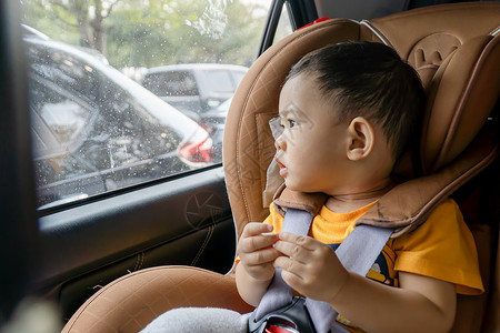 在车上的座椅上贴近了小男孩腰带车辆男性窗户汽车男生旅行幸福家庭婴儿安全高清图片素材