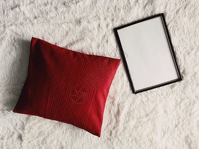 白色格子框架带有空白复制空间的黑色薄木框作为海报照片打印模型 红色垫枕和蓬松的白色毯子 平躺背景和艺术产品家具摄影风格平铺商业织物木头格子羽背景