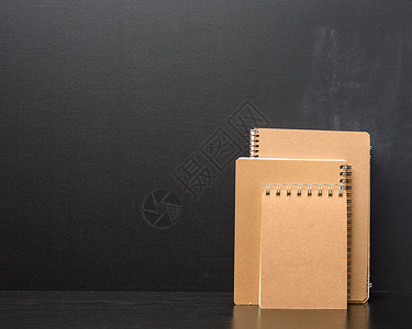 黑色背景的棕色纸片封闭笔记板教育软垫空白笔记备忘录床单笔记纸活页螺旋日记背景图片