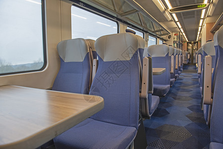 内地空的 坐有座位的通车客运列车窗户桌子天花板走道椅子景观旅行农村铁路行李架背景图片