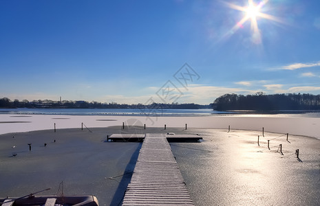 在德国阳光明媚的一天 雪在冰冻湖边覆盖了木制码头探索新雪蓝色木头天空旅游公园冷冻金字塔风景背景图片