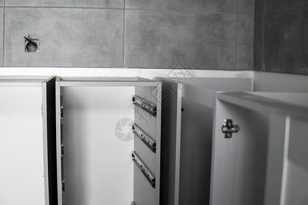 不锈钢伸缩卡口式抽屉滑轨 安装在灰色刨花板制成的厨柜上 用于家具制造的木工配件 定制厨房安装螺丝刀木板架子内阁建造贮存材料橱柜导背景图片