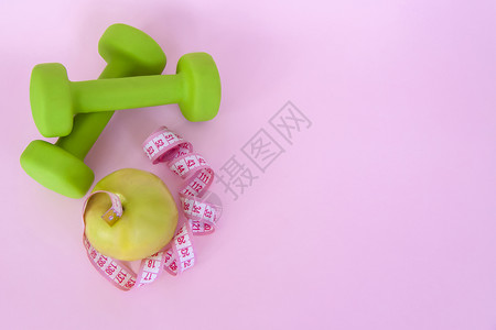 绿色苹果和粉红色背景的厘米测量胶带 运动 体育营养 健康饮食 饮食 文字空间 笑声哑铃活动速度仪器腰部技术背景图片