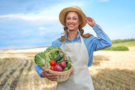 女农民草帽围裙站在农田微笑女农学家专家农业综合企业快乐积极的白人工人农业领域收集采摘帽子生长生态蔬菜稻草小麦女性农场背景图片