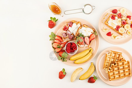 香蕉干草莓干带水果和浆果 奶油和蜂蜜的自制华夫饼 放在白桌上的一个盘子上小吃桌子正方形早餐甜点食物香蕉美食覆盆子乡村背景
