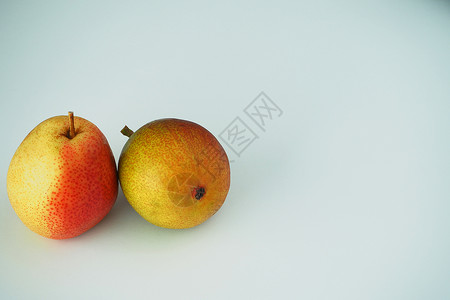 水果 两颗梨子紧贴在白色背景上图片梨园收成维生素季节花园红色甜点黄色美味背景图片