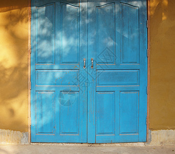 蓝木木门和黄墙背景图片