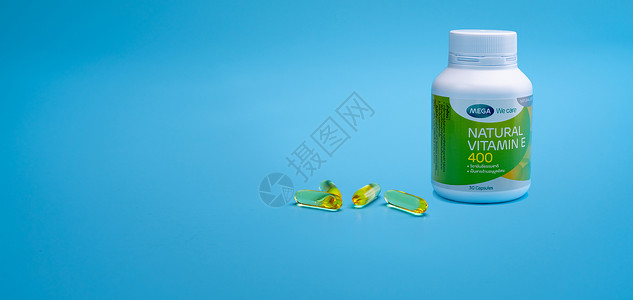 泰国春武里-2021 年 1 月 31 日 天然维生素 E 400 IU 装在 PP 塑料瓶中 四个软明胶胶囊装在蓝色背景中 的背景图片