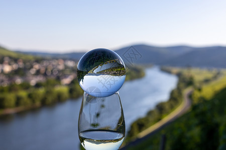 装有晶球和背景景观的灌满葡萄酒杯背景图片