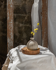 木板上手工陶瓷花瓶中的干花 家居装饰印花布织物叶子潮人陶器制品地面植物房间麻布背景图片