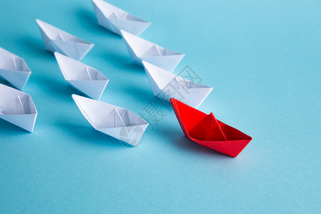 红领头纸船在蓝背景上领先 领导理念 掌舵团体折纸钥匙经理旅行竞赛导师统治成功优胜者背景图片