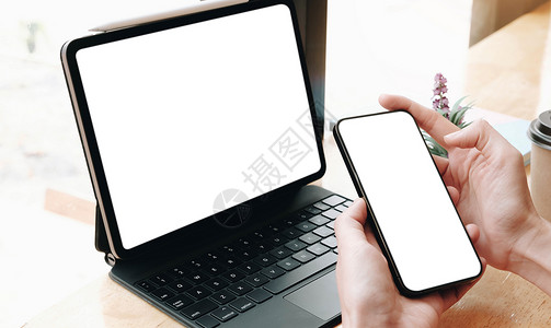 顶级女性坐着 拿着空白的屏幕 模拟手机和电脑 掌声商业成人细胞女孩咖啡店互联网白色电话技术网络背景图片
