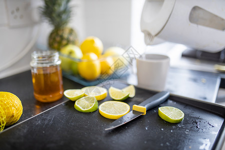 保温罐主图柠檬和石灰片放在蜂蜜罐子旁边的托盘上水果茶壶保温壶水壶玻璃饮料容器菠萝准备烹饪背景