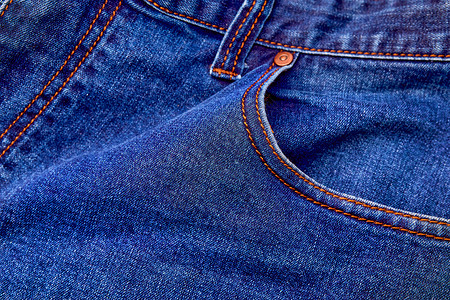 Blue denim牛仔裤背景口袋 缝合和橙色线缝合牛仔布标签编织插图褪色青年铆钉崎岖服饰靛青背景图片