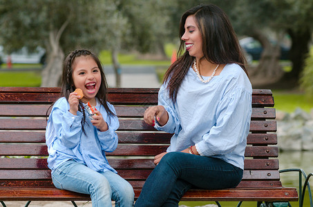 母亲和女儿坐在长凳上 吃饼干吃曲奇饼孩子拥抱家庭童年成人闲暇父母婴儿幸福女性女孩高清图片素材