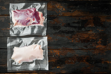 包装袋中生鸭胸 用于做sous vide的烹饪 旧黑木板桌底 复制空间和文字空间背景