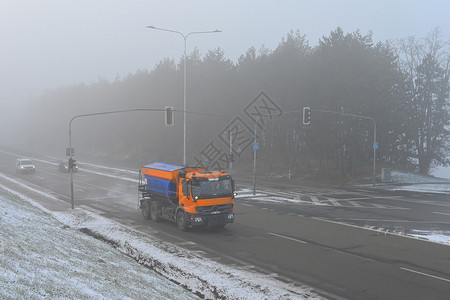 雪犁卡车 冬天时有雾和交通高清图片