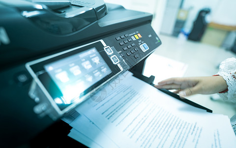 机器打印办公室工作人员在多功能激光打印机上打印纸张 办公室内的复印 打印 扫描和传真机 现代印刷技术 复印机 文件和文书工作 扫描器 秘背景