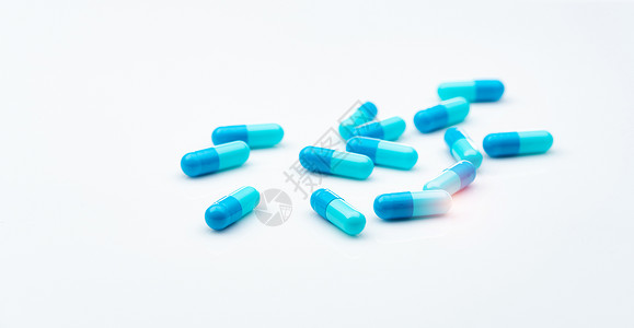 在白色背景上传播的蓝色抗生素胶囊药丸 抗生素耐药性 医药行业 医疗保健和医学概念 健康预算概念 胶囊制造业生产青霉素药片处方肌肉背景图片