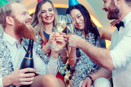 一群朋友在酒吧里喝着香槟和庆祝的烤面包眼镜高清图片素材