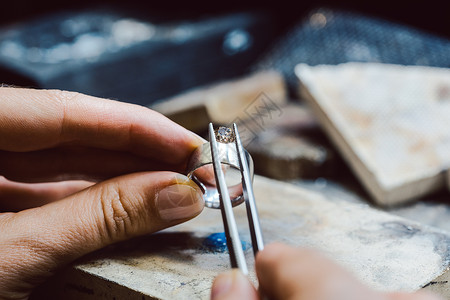 珠宝首饰在戒指上架设一枚宝石创造力工具男人环境评价作坊工作手工工匠维修背景图片