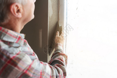 窗口打开时工作的粉碎器工人绝缘瓦工男人涂层工地水泥房子建筑工人泥水匠背景图片