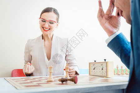 商业妇女因更好的策略在象棋中获胜游戏商务棋盘谈判木板棋局喜悦战略女士人士背景图片