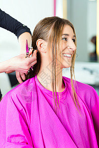 接受发型师或理发师理发的妇女发型设计护理发型成人店铺顾客女性造型服务梳子理发店高清图片素材