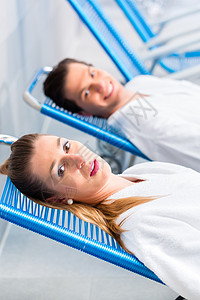 两人在舒适的温泉疗养所躺椅朋友们夫妻男人友谊浴衣娱乐女士背景图片