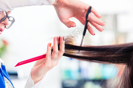 理发师在店里剪妇女头发店铺修剪职业发型女士沙龙女性理发店理发工作年轻的高清图片素材