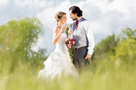 新娘和新郎在草地上结婚 配有新娘花束玫瑰高清图片素材