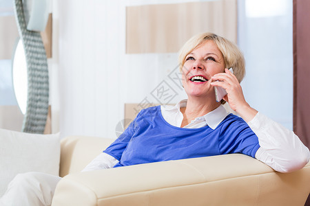 坐在沙发上的家庭用高级妇女电话思维长椅呼唤八卦沉思背景图片