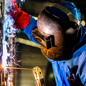 在工业工厂工作的焊接工建造工人面具场所生产作坊火花工具劳动员工工业的高清图片素材