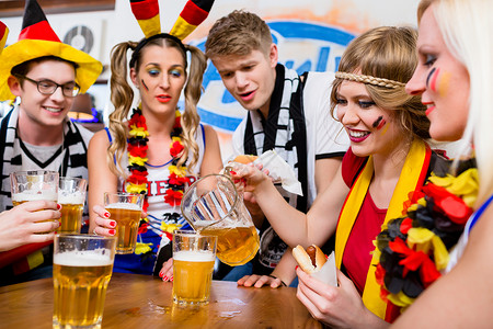 足球球迷观看德国国家队的一场比赛电视国家化妆品锦标赛风扇女性乐趣居住国家队朋友们背景图片