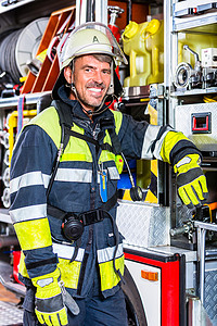 身穿防护服的消防员 靠在消防引擎上作用力防火总部女士火灾警报工作车辆服务消防车背景图片
