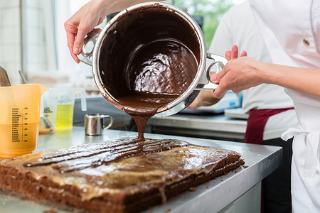 化巧克力为蛋糕霜冻的摄录器糕点师传统质量店铺生意甜点女性面包师糖果商生产背景