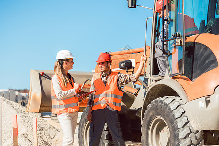 关于道路建设工地的土木工程师和工人讨论女士商业工业工程笔记挖掘职业工作橙子标志轮式装载机高清图片素材