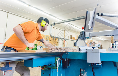带有表锯的木匠切削板体力劳动工匠木工橱柜男人职业劳动木头工作台作坊锯切高清图片素材