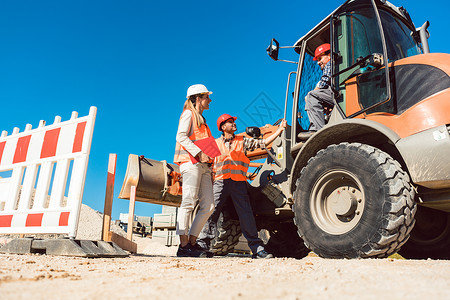 关于道路建设工地的土木工程师和工人讨论挖掘女士土方笔记职业工业工作橙子标志建筑工人建造高清图片素材