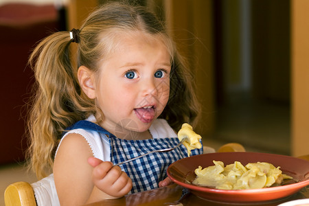 女孩吃面食食物孩子女性饺子午餐盘子饥饿婴儿背景图片