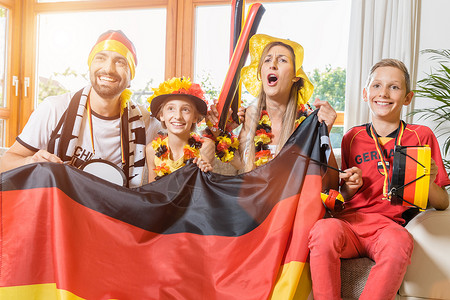 整个家庭都在电视前为德国足球队欢呼女性母亲父母胜利男人支持者女儿居住播送孩子们背景图片