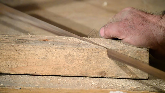 用手锯砍木板职业木材工人木工运动锯末刀刃工艺金属工匠背景图片