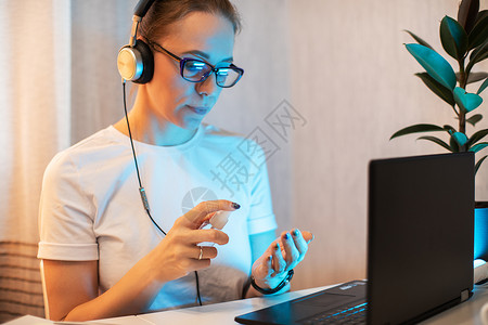 女人对电话表面进行消毒病菌卫生液体电脑笔记本商务互联网面具消毒剂员工医生高清图片素材