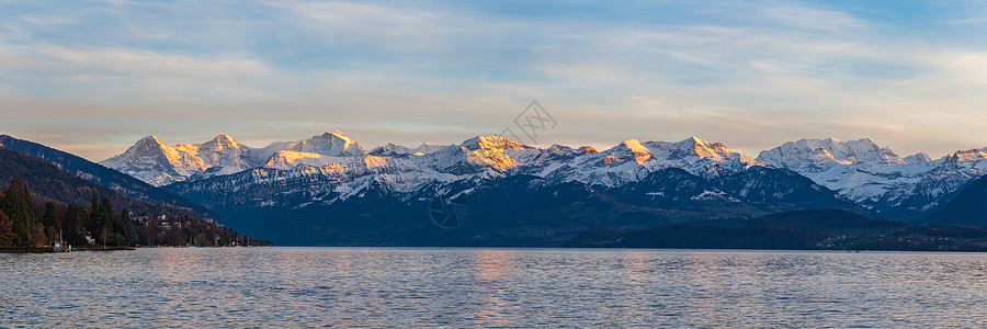瑞士阿尔卑斯山峰在伯尔尼奥伯兰艾格尔北面 蒙奇 来自通湖(图纳西)日落秋天黄昏时正frau 位于瑞士伯恩市Bern背景图片