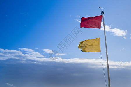 海上危险警示旗帜红色黄色警告救生员波浪海岸线海滩飓风海岸支撑背景图片