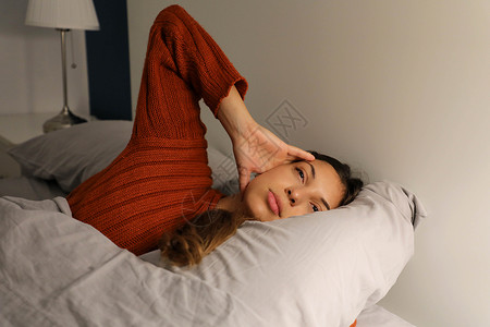 床上睡着患有头痛失眠 偏头痛的年轻女性嘈杂高清图片素材