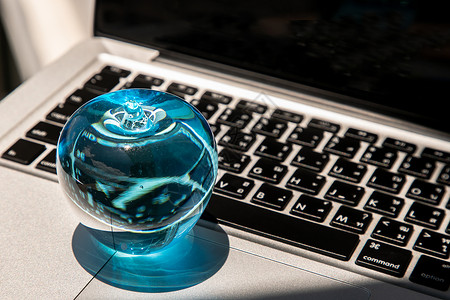 玻璃上纽扣笔记本电脑键盘上玻璃水晶蓝苹果的特写字母电子技术互联网反射阳光纽扣网络黑色商业背景
