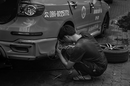 2019年6月29日 修车的男子修理一辆黑色和白色出租车背景图片